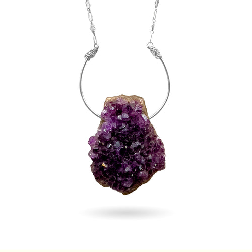 This natural rough Amethyst geode from the mines of Hiddenite, NC is set on a solid sterling silver semi-circle pendant attached to a long ornate sterling silver art-deco style chain and finished with a vintage-inspired pearl box clasp. 