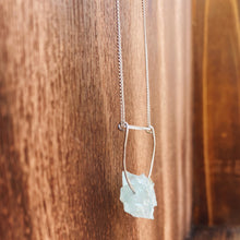 Load image into Gallery viewer, This beautiful cluster of natural rough Aquamarine stones are set on a sterling silver half-circle, hung from a dainty sterling silver curb chain, and finished with a vintage-inspired pearl box clasp.
