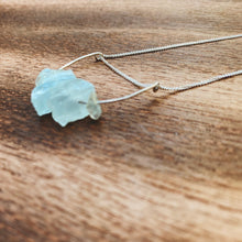 Load image into Gallery viewer, This beautiful cluster of natural rough Aquamarine stones are set on a sterling silver half-circle, hung from a dainty sterling silver curb chain, and finished with a vintage-inspired pearl box clasp.
