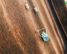 Load image into Gallery viewer, This beautiful natural mined rough Aquamarine stone is set on a sterling silver half-circle, hung from a dainty sterling silver rectangular paperclip cable chain, adorned with Freshwater Pearls (six in total), and finished with a vintage-inspired pearl box clasp.
