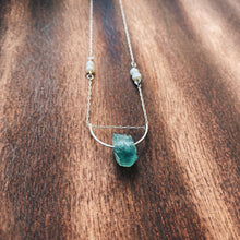 Load image into Gallery viewer, This beautiful natural mined rough Aquamarine stone is set on a sterling silver half-circle, hung from a dainty sterling silver rectangular paperclip cable chain, adorned with Freshwater Pearls (six in total), and finished with a vintage-inspired pearl box clasp.
