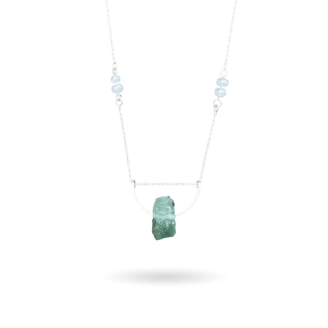 This beautiful natural mined rough Aquamarine stone is set on a sterling silver half-circle, hung from a dainty sterling silver rectangular paperclip cable chain, adorned with Freshwater Pearls (six in total), and finished with a vintage-inspired pearl box clasp.