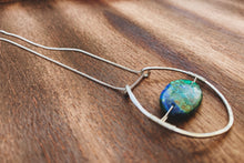 Load image into Gallery viewer, This stunning natural, mined Azurite-Malachite-Chrysocolla Pendant is 9.25 carats and has been polished into an oval cabochon and suspended upon sterling silver wire amid a sterling silver horseshoe shaped ring pendant, which hangs upon a smooth, dainty sterling silver curb chain.
