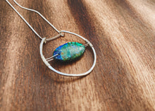 Load image into Gallery viewer, This stunning natural, mined Azurite-Malachite-Chrysocolla Pendant is 9.25 carats and has been polished into an oval cabochon and suspended upon sterling silver wire amid a sterling silver horseshoe shaped ring pendant, which hangs upon a smooth, dainty sterling silver curb chain.
