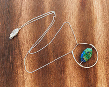 Load image into Gallery viewer, This stunning natural, mined Azurite-Malachite-Chrysocolla Pendant is 9.25 carats and has been polished into an oval cabochon and suspended upon sterling silver wire amid a sterling silver horseshoe shaped ring pendant, which hangs upon a smooth, dainty sterling silver curb chain.
