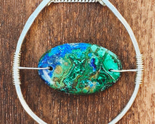 Load image into Gallery viewer, This stunning natural, mined Azurite-Malachite-Chrysocolla Pendant is 9.25 carats and has been polished into an oval cabochon and suspended upon sterling silver wire amid a sterling silver horseshoe shaped ring pendant, which hangs upon a smooth, dainty sterling silver curb chain.
