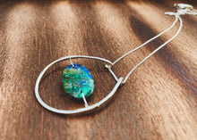 Load image into Gallery viewer, This stunning natural, mined Azurite-Malachite-Chrysocolla Pendant is 9.25 carats and has been polished into an oval cabochon and suspended upon sterling silver wire amid a sterling silver horseshoe shaped ring pendant, which hangs upon a smooth, dainty sterling silver curb chain.
