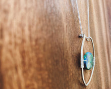 Load image into Gallery viewer, This stunning natural, mined Azurite-Malachite-Chrysocolla Pendant is 9.25 carats and has been polished into an oval cabochon and suspended upon sterling silver wire amid a sterling silver horseshoe shaped ring pendant, which hangs upon a smooth, dainty sterling silver curb chain.
