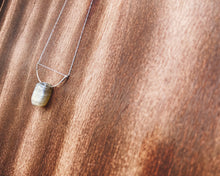 Cargar imagen en el visor de la galería, This stunning natural Black Moonstone gemstone has colors of slate grey and tan with a velvety silver flash across the surface when it is moved about in the light. This naturally-shaped Black Moonstone is set on a sterling silver half-circle, hung from a dainty sterling silver paper clip cable chain, and finished with a vintage-inspired pearl box clasp. The perfect necklace for those looking for a minimal design, but still want a unique gemstone rarely seen in most jewelry collections.
