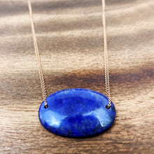 Load image into Gallery viewer, Lapis Lazuli is known as the stone of friendship and a crystal of truth. This natural Lapis Lazuli gemstone is polished into an oval cabochon and strung on a dainty 14K gold-fill rose gold cable chain, which has been doubled up on both sides, and completed with a vintage-inspired pearl box clasp.
