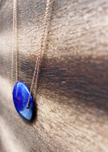 Load image into Gallery viewer, Lapis Lazuli is known as the stone of friendship and a crystal of truth. This natural Lapis Lazuli gemstone is polished into an oval cabochon and strung on a dainty 14K gold-fill rose gold cable chain, which has been doubled up on both sides, and completed with a vintage-inspired pearl box clasp.
