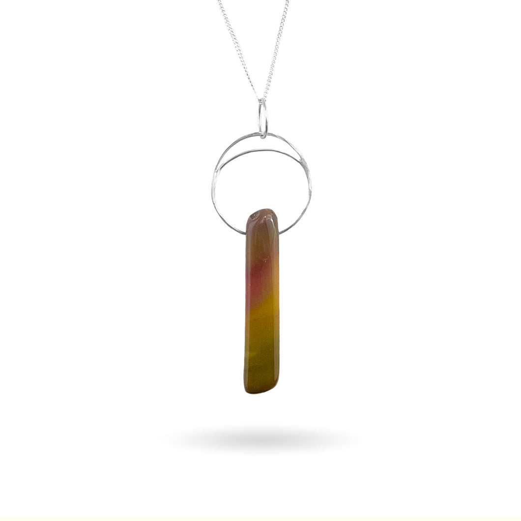 This natural Mookaite gemstone has been polished into a long rectangular shape and hung from a hammered sterling silver circle/half moon pendant and strung on a sterling silver curb chain. This stone is uniquely attractive with plenty of color including pink, green, yellow, mauve, red, and gray.