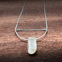 Load image into Gallery viewer, This silky natural Moonstone gemstone has an almost magical pearly iridescence. This Moonstone is from the mines of North Carolina and is supported by a hammered sterling silver half moon pendant and strung along a dainty sterling silver curb chain then finished with a vintage-inspired pearl box clasp.
