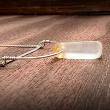 Load image into Gallery viewer, This silky natural Moonstone gemstone has an almost magical pearly iridescence. This Moonstone is from the mines of North Carolina and is supported by a hammered sterling silver half moon pendant and strung along a dainty sterling silver curb chain then finished with a vintage-inspired pearl box clasp.
