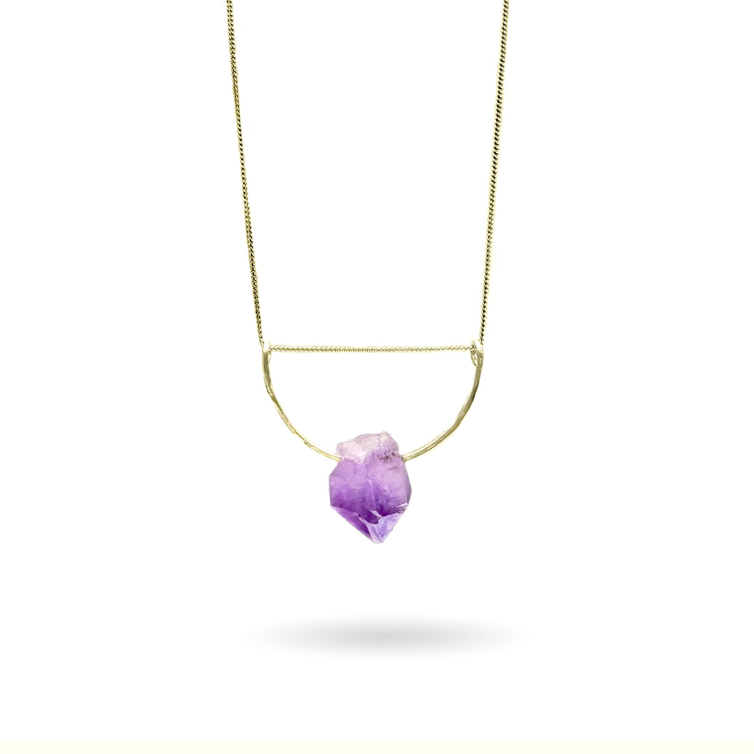 A pastel purple crystal point of Fluorite hangs from a hammered 14K gold-fill half-circle pendant and is strung along a dainty 14K gold-fill curb chain, then finished with a vintage-inspired pearl box clasp. 